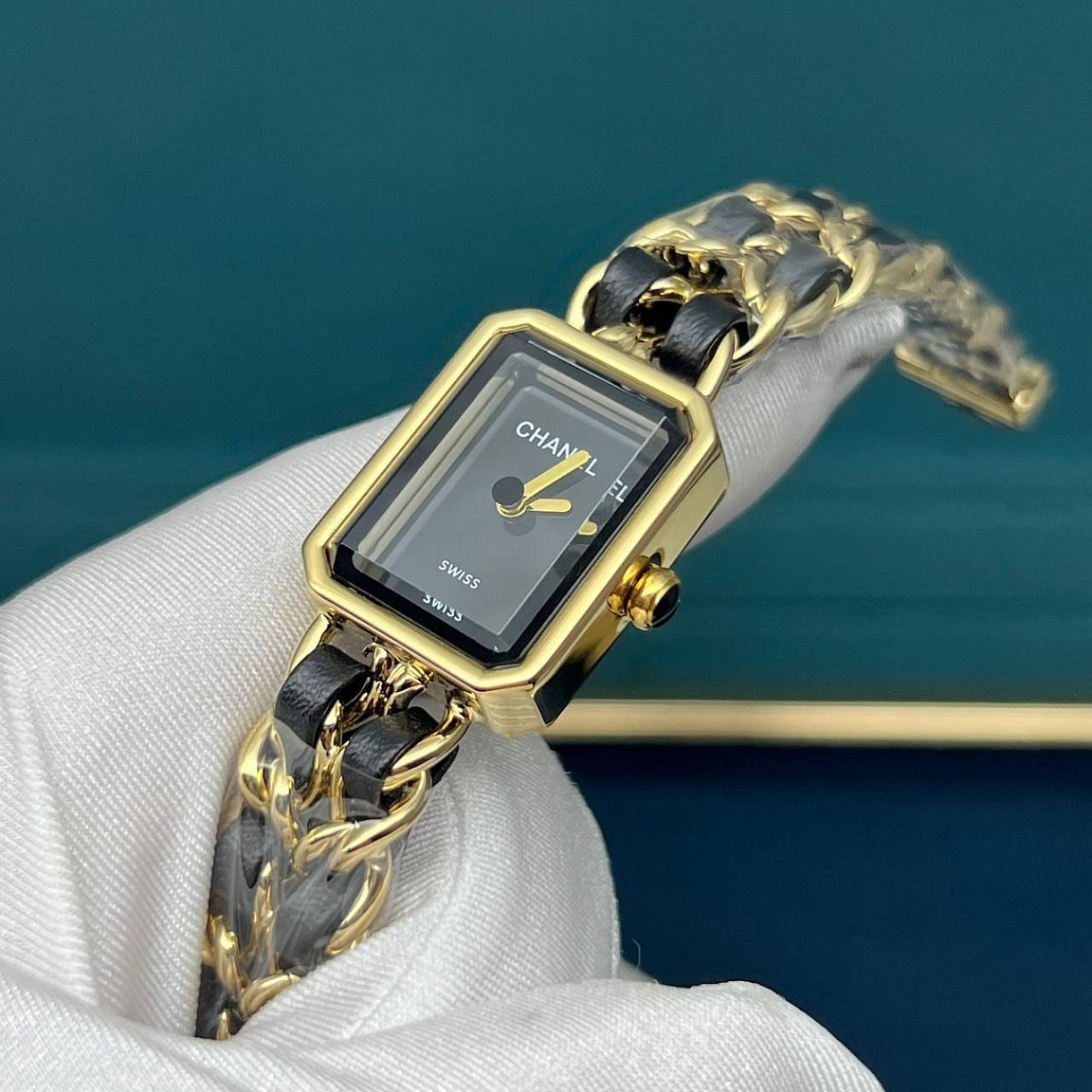 Часы CHANEL Première с двумя золотистыми стрелками на чёрном циферблате и цепочным браслетом с кожаным переплетением