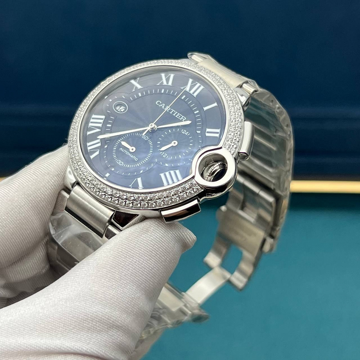 Cartier Ballon Blue 46 мм: полированный корпус и звенья браслета, чёрный циферблат с датой у отметки IX