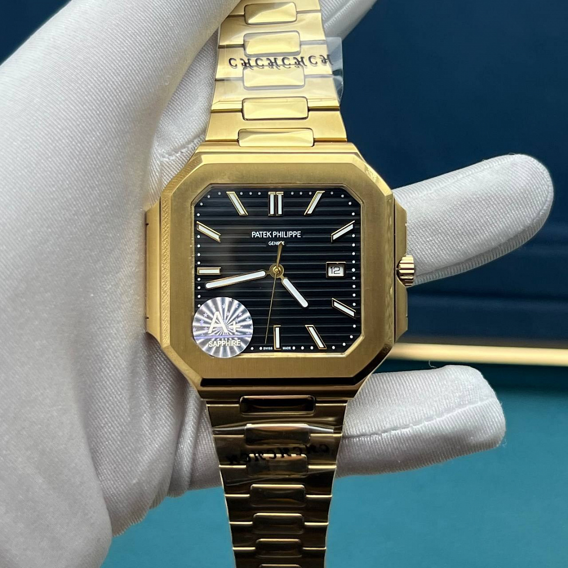 Patek Philippe Cubitus: квадратный золотистый корпус 45 мм, чёрный рельефный циферблат и дата у отметки «3»