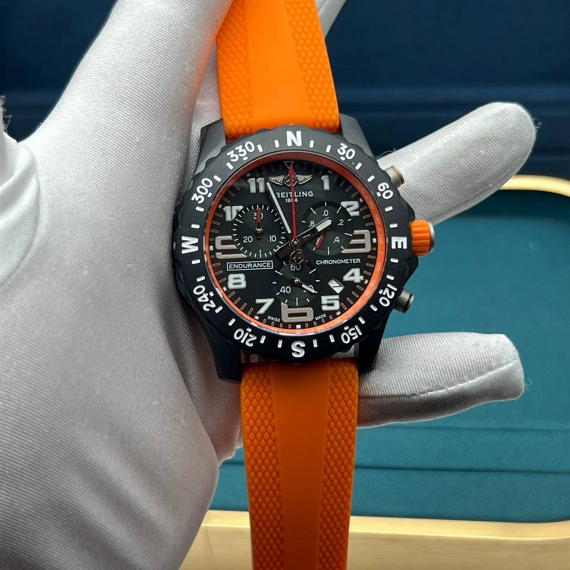 Часы Breitling Endurance Pro 43 мм: светлые арабские цифры на чёрном циферблате, оранжевый каучуковый ремешок