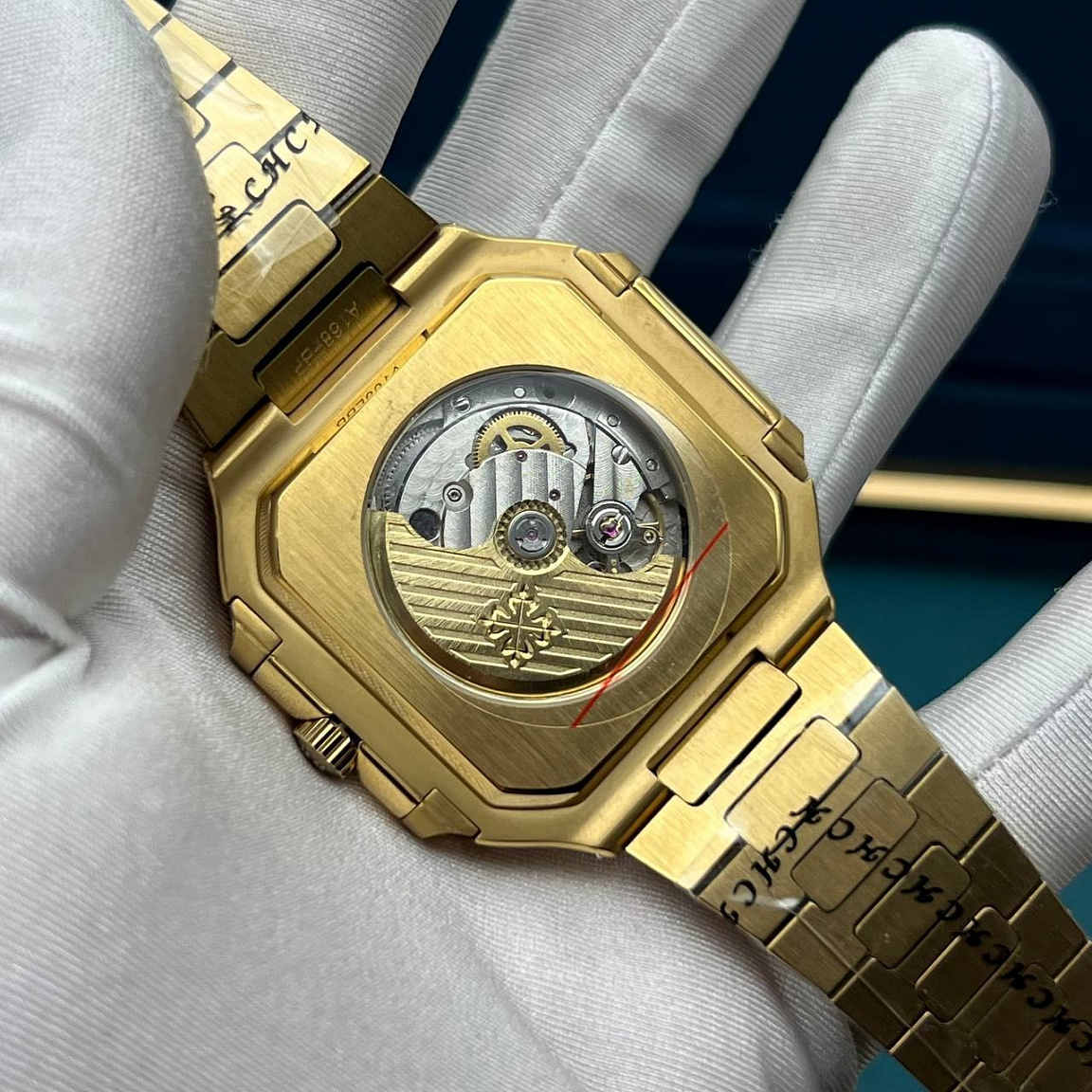 Patek Philippe Cubitus: квадратный золотистый корпус 45 мм, чёрный рельефный циферблат и дата у отметки «3»