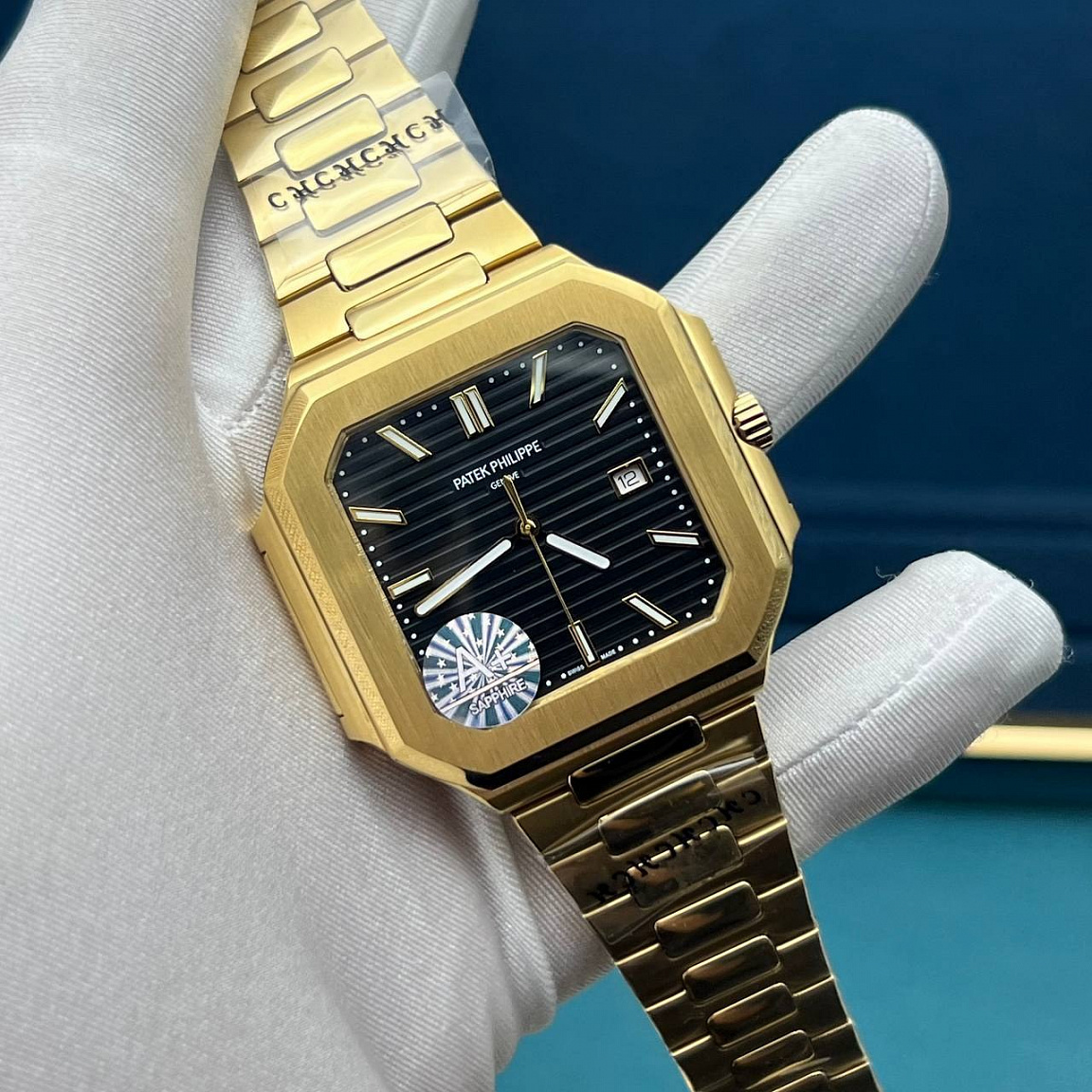 Patek Philippe Cubitus: квадратный золотистый корпус 45 мм, чёрный рельефный циферблат и дата у отметки «3»