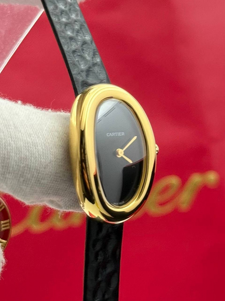 Овальные Cartier Baignoire 26 мм: золотистые стрелки на чёрном циферблате, фактурный ремешок из натуральной кожи