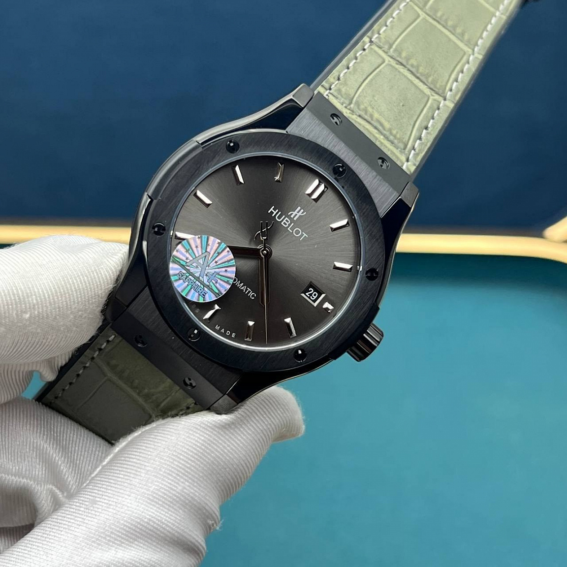 Часы Hublot Classic Fusion 45 мм: серый циферблат с датой у отметки «3», безель с шестью винтами, оливковый ремешок