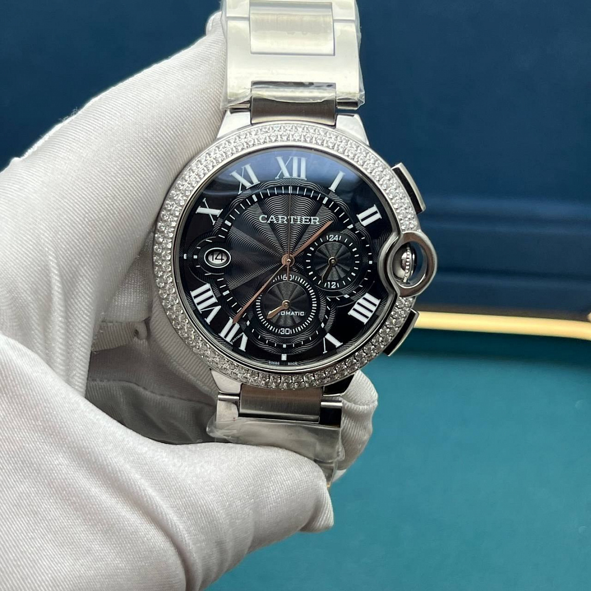 Cartier Ballon Blue 46 мм: полированный корпус и звенья браслета, чёрный циферблат с датой у отметки IX