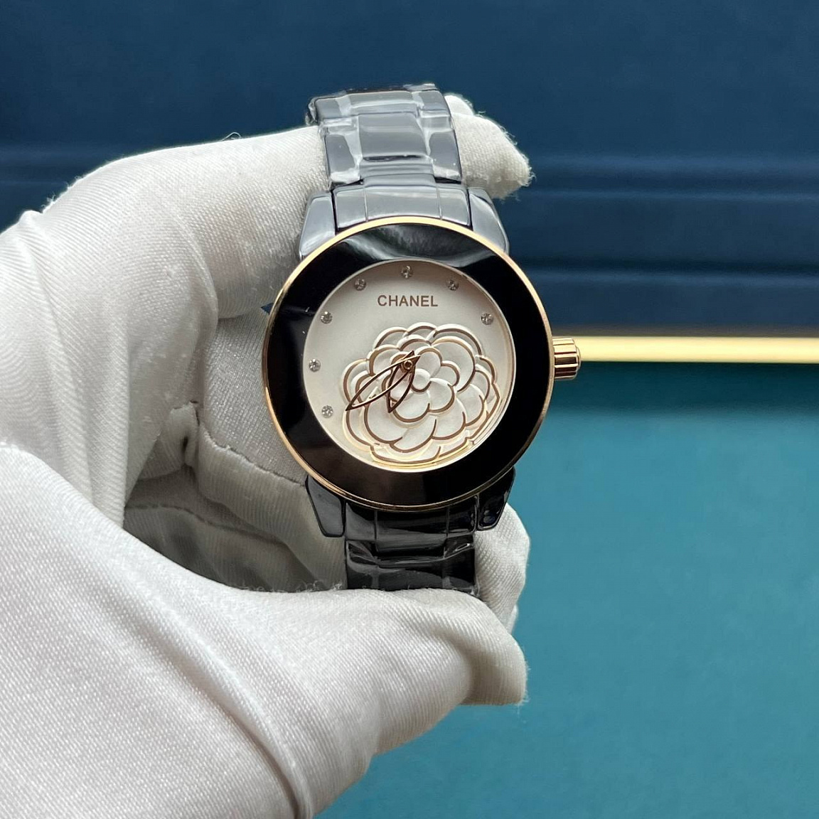 Камелия на белом циферблате CHANEL J12 Camélia 33 мм, чёрная керамика и золотистые акценты