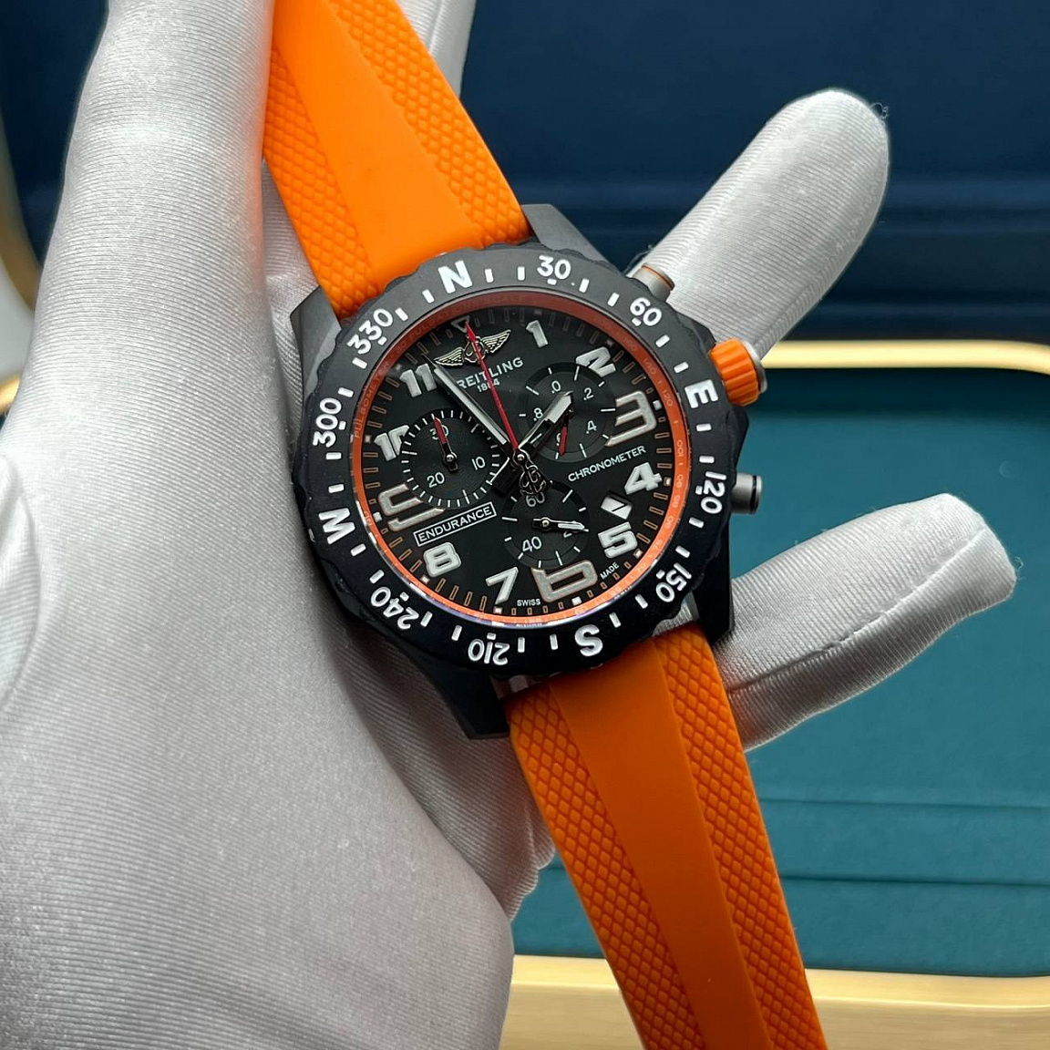 Часы Breitling Endurance Pro 43 мм: светлые арабские цифры на чёрном циферблате, оранжевый каучуковый ремешок