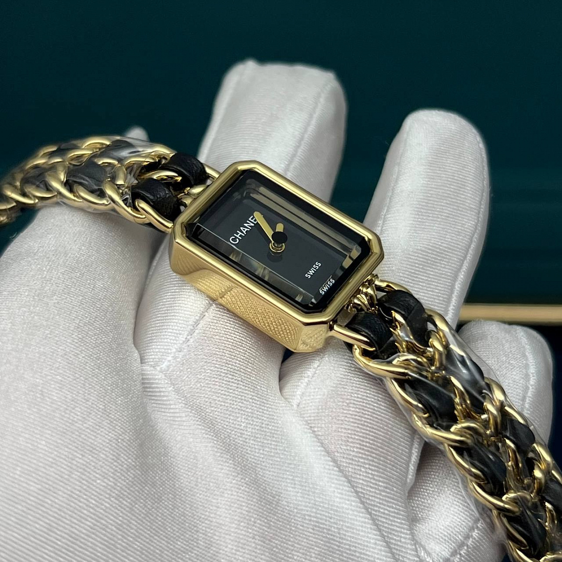 Часы CHANEL Première с двумя золотистыми стрелками на чёрном циферблате и цепочным браслетом с кожаным переплетением