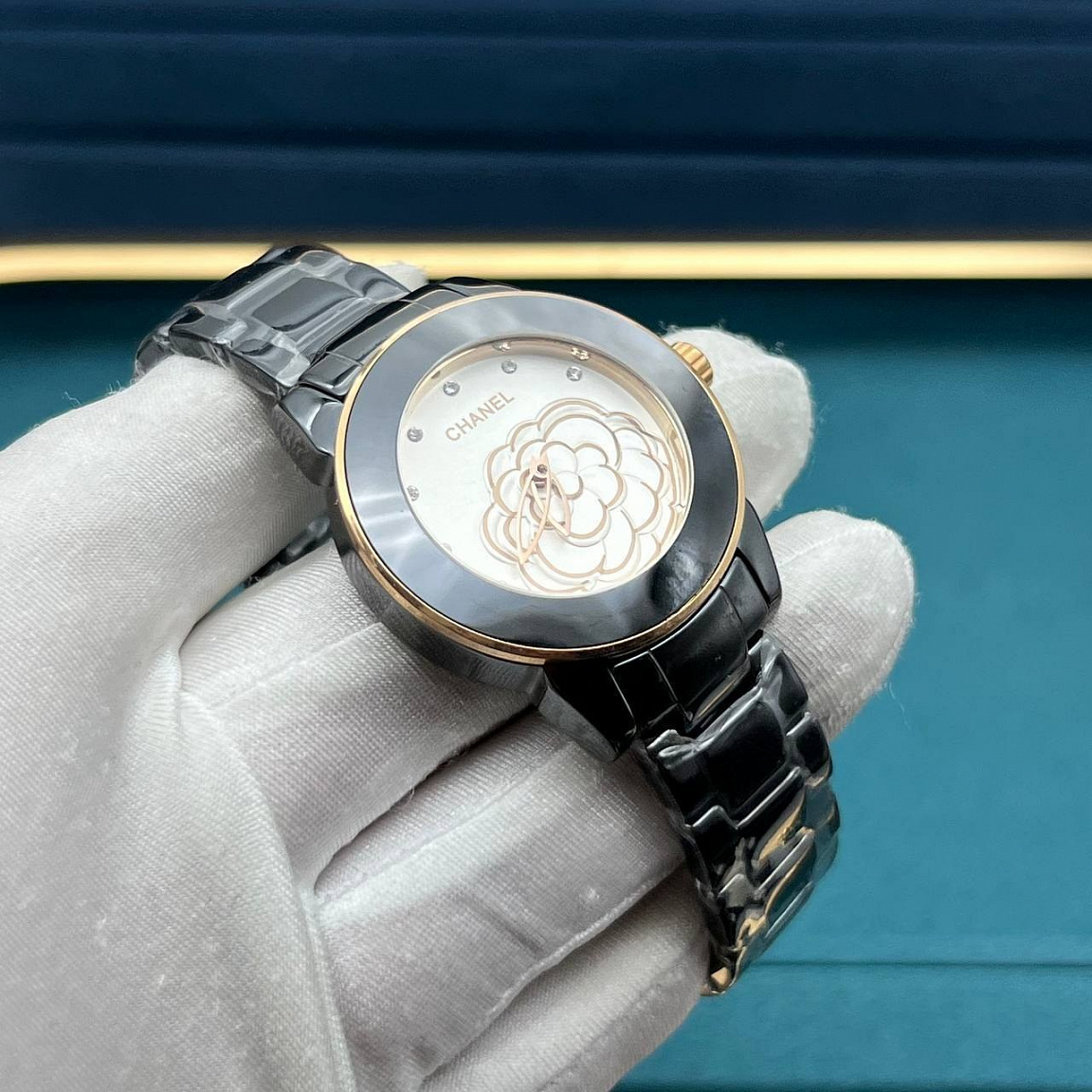 Камелия на белом циферблате CHANEL J12 Camélia 33 мм, чёрная керамика и золотистые акценты