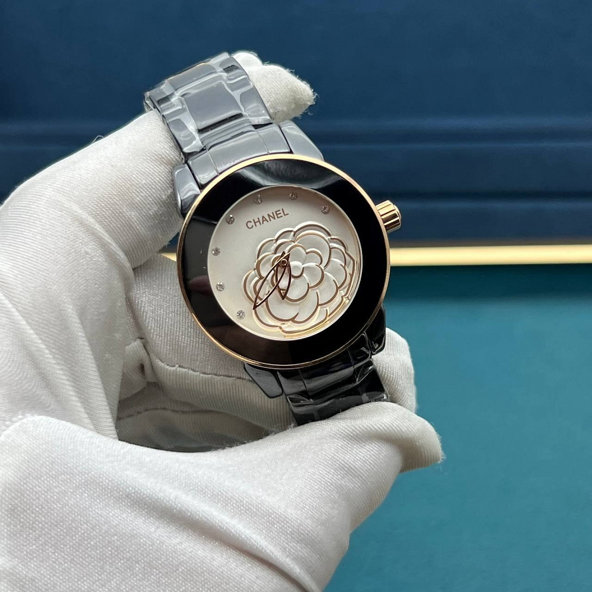 Камелия на белом циферблате CHANEL J12 Camélia 33 мм, чёрная керамика и золотистые акценты