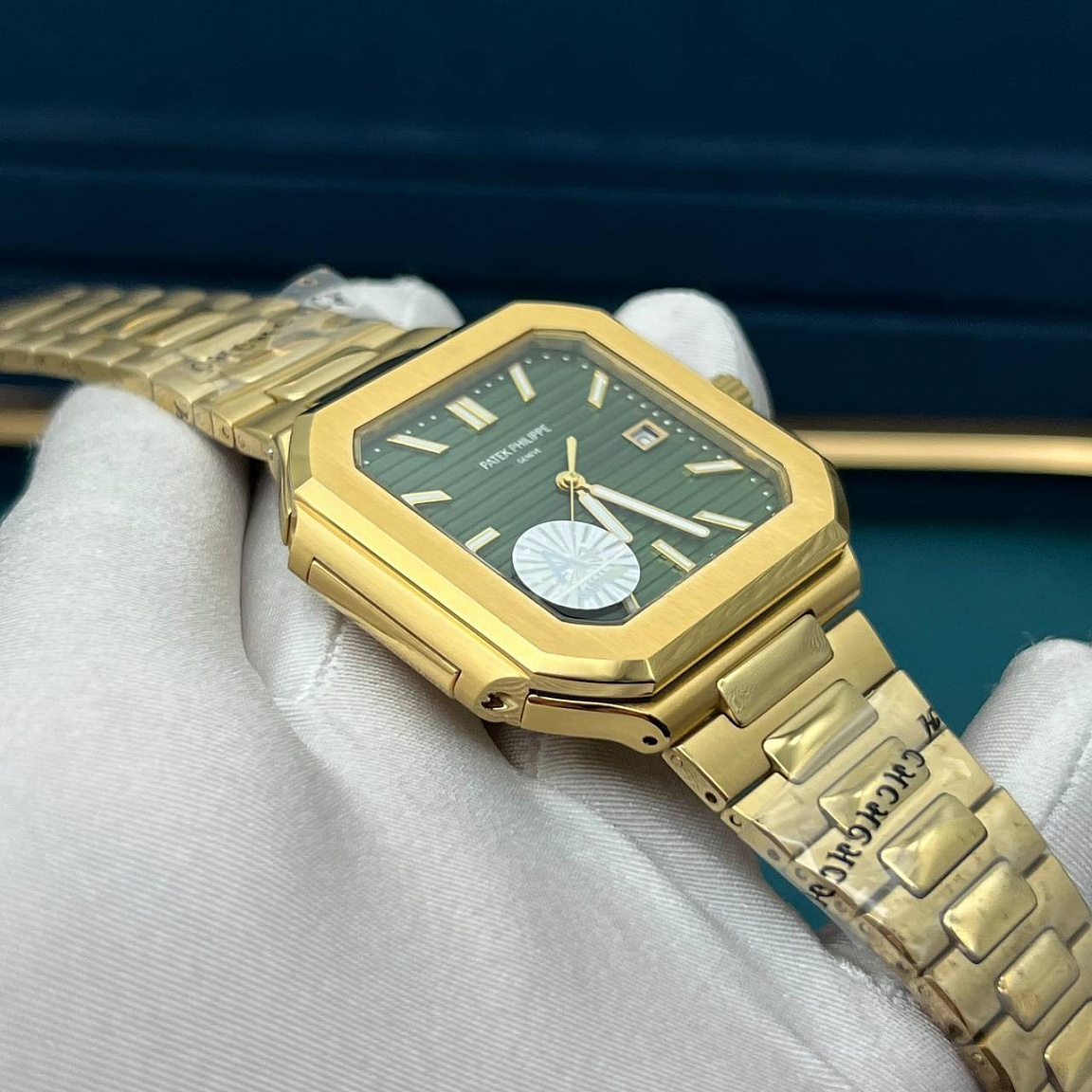 Patek Philippe Cubitus: квадратный золотистый корпус, зелёный циферблат с датой и горизонтальным рельефом