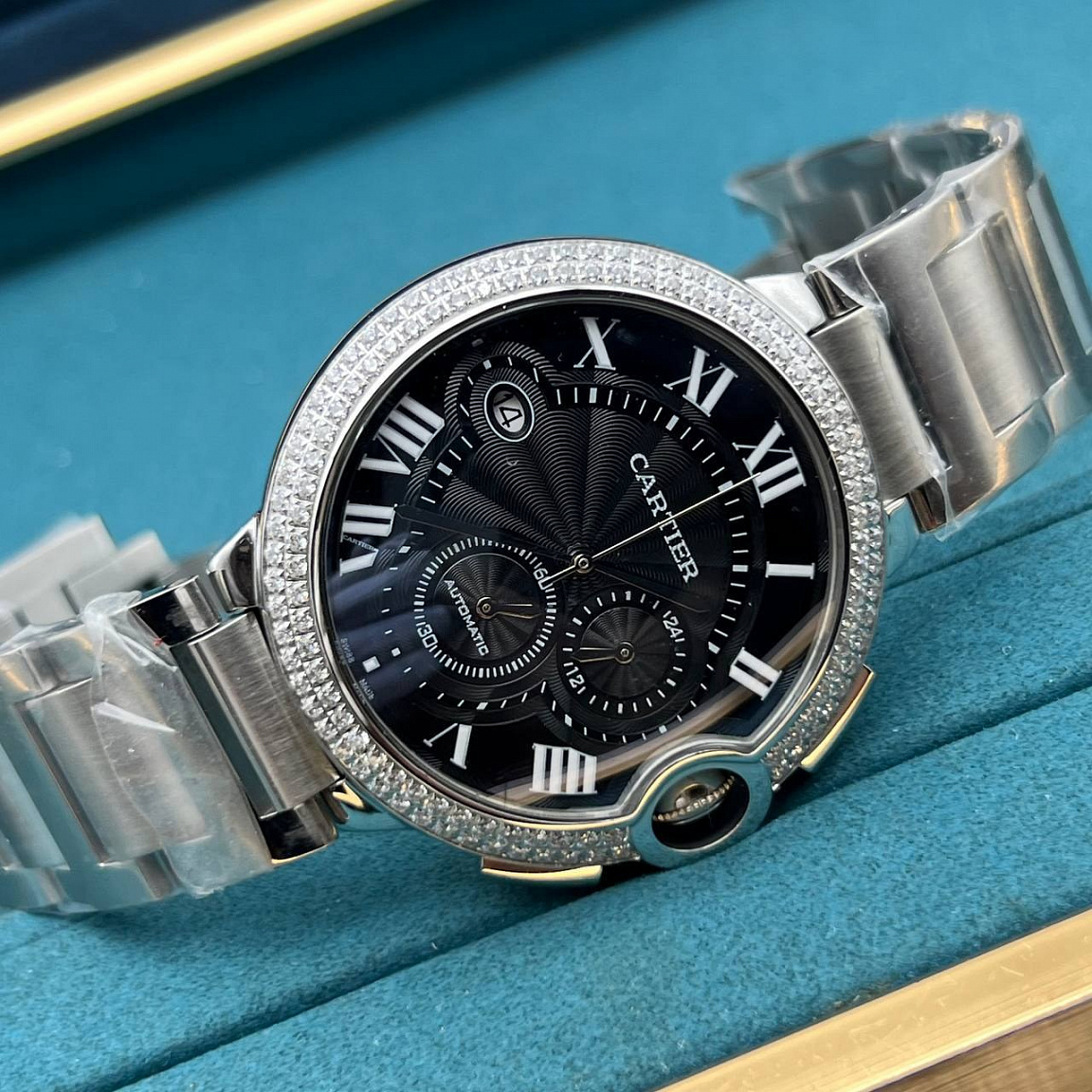 Cartier Ballon Blue 46 мм: полированный корпус и звенья браслета, чёрный циферблат с датой у отметки IX